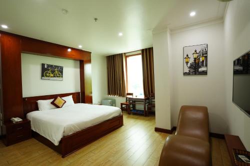 um quarto de hotel com uma cama e uma cadeira em Thành Vinh Hotel em Ho Chi Minh