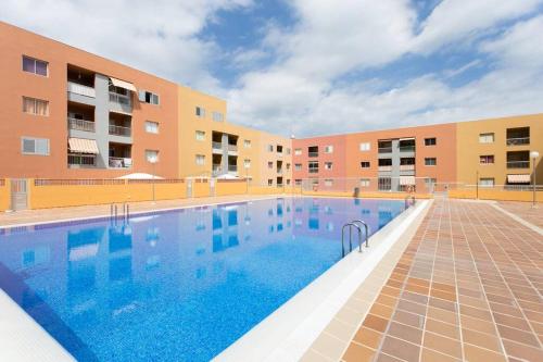 a large swimming pool in front of a building at Cálido apartamento, piscina, Wi-Fi in Candelaria