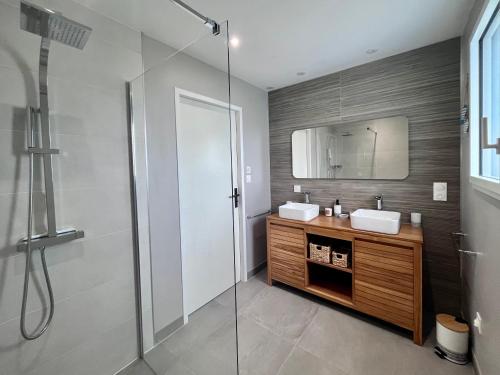 La salle de bains est pourvue d'une douche, de 2 lavabos et d'un miroir. dans l'établissement La maison du Petit Pin, à La Tranche-sur-Mer
