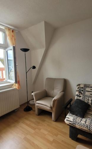 a living room with a chair and a lamp at Home of Your Dreams in Plauen