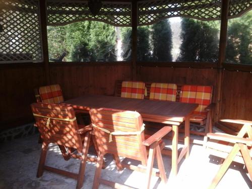 a wooden table and chairs in a screened porch at Penzion Adam - Makov in Makov