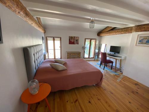 une chambre avec un grand lit et un bureau dans l'établissement Appartement atypique sous les toits d'Avignon au cœur de l'intra-muros avec parking, à Avignon
