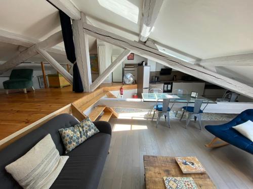 un salon avec un canapé et une table dans l'établissement Appartement atypique sous les toits d'Avignon au cœur de l'intra-muros avec parking, à Avignon