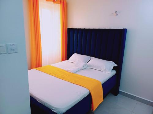 a bed with a black headboard and two pillows at Medzam Homes Spacious Newly Furnished Studio in Mombasa