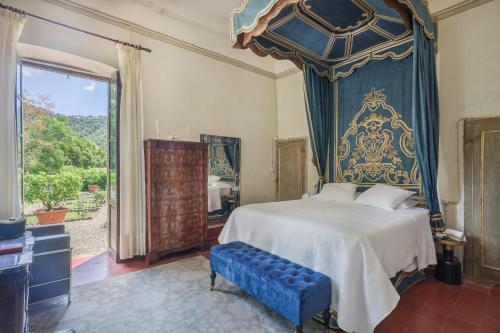 a bedroom with a large bed with a blue canopy at Villa Sardi Small Luxury boutique Hotel in Lucca
