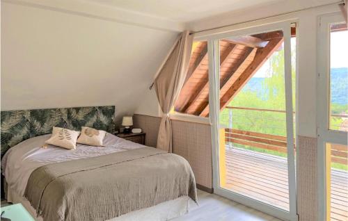 1 dormitorio con cama y ventana grande en Cozy Home In La Vancelle With Outdoor Swimming Pool, en La Vancelle