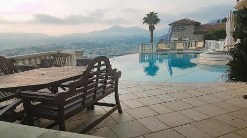 - une table et des chaises à côté de la piscine dans l'établissement Roc Maria Lucia, à Nice