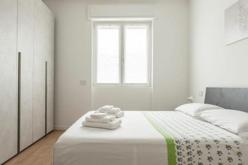 a white bedroom with a bed with towels on it at My home in Lecco