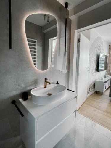 a white bathroom with a sink and a mirror at Penthouse Słoneczna Rapsodia - Nowoczesny Apartament z dużym Tarasem i Pięknym Widokiem przy Parku Zdrojowym in Rabka-Zdrój