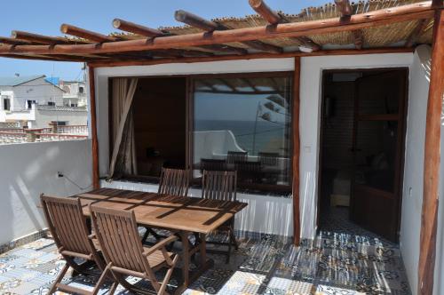 een houten tafel en stoelen op een balkon bij KABANO BEACH AUBERGE CAFE RESTAURANT in Moulay Bousselham