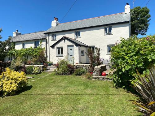 a white house with a yard in front of it at Stunning Cottage Close to Amazing Beaches in Braunton