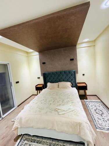 a bedroom with a large bed with a green headboard at Petite villa a hay dakhla in Agadir