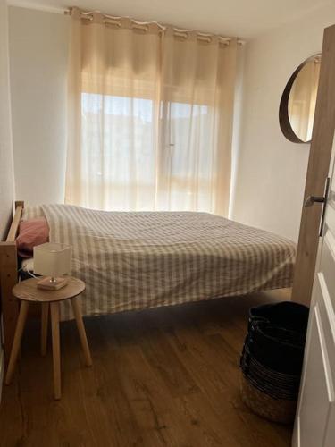 a bedroom with a bed and a window with a table at Appartement Centre Annemasse, direct tram Geneve in Annemasse