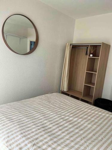 - une chambre avec un lit et un grand miroir dans l'établissement Appartement Centre Annemasse, direct tram Geneve, à Annemasse
