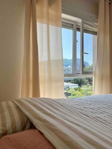 a bedroom with a bed and a window at Appartement Centre Annemasse, direct tram Geneve in Annemasse