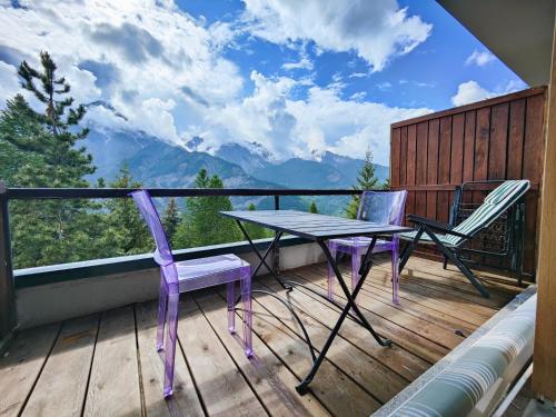 a table and chairs on a balcony with a view at Hostdomus - Sansicario R9 in Cesana Torinese