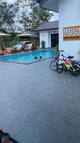 two bikes parked next to a swimming pool at Villa The Quarry in Segamat