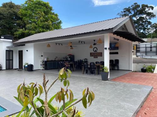 een wit gebouw met een dak en een patio bij Villa The Quarry in Segamat