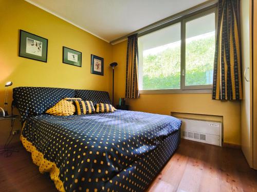 a bedroom with a bed with polka dot sheets and a window at Hostdomus - Sansicario R9 in Cesana Torinese