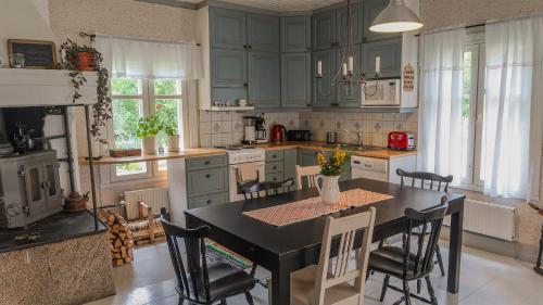uma cozinha com uma mesa preta e cadeiras em Lillstugan em Vöyri