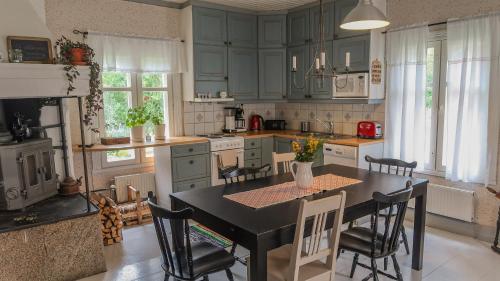 a kitchen with a black table and chairs in it at Lillstugan in Vöyri