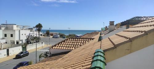 einen Blick auf die Dächer einer Stadt mit dem Meer in der Unterkunft islantilla ático 1 linea de playa vistas al mar in Islantilla