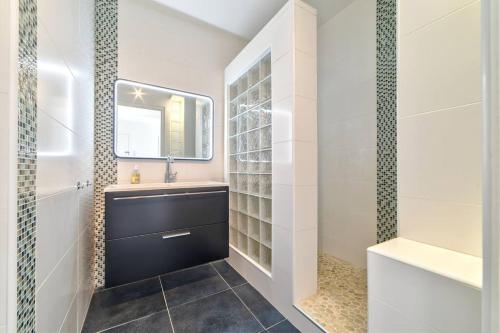 une salle de bain avec un lavabo et un miroir dans l'établissement ROSE DES SABLES, à Antibes