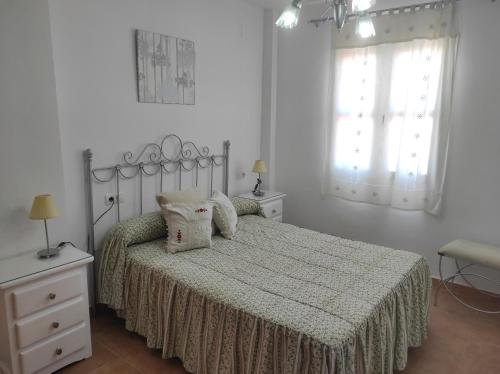 ein weißes Schlafzimmer mit einem Bett und einem Fenster in der Unterkunft islantilla ático 1 linea de playa vistas al mar in Islantilla