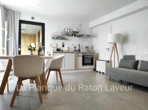 a kitchen and living room with a table and a couch at La planque du raton laveur in Lierneux
