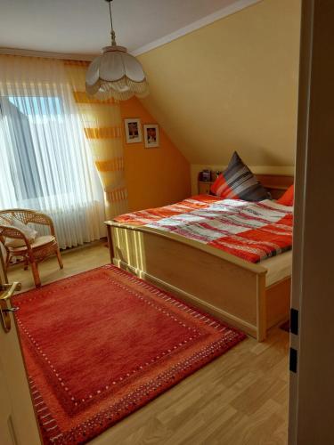 1 dormitorio con 1 cama con edredón rojo en Ferienwohnung „Leni“, en Meppen