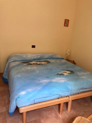 a bed with a blue blanket on top of it at appartamento in Nocera Umbra