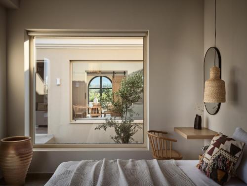 a bedroom with a window looking out onto a patio at Uvetta Villa in Makhairádhon