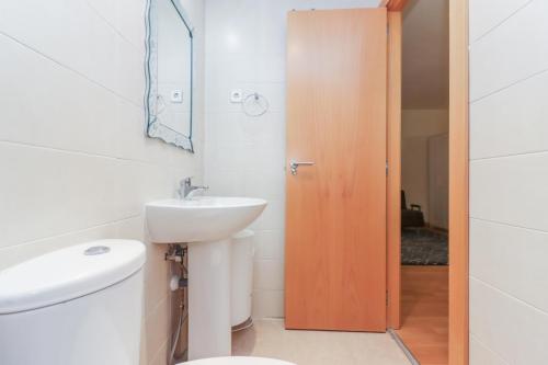 a bathroom with a toilet and a sink at Bright duplex apartment for families-VICALV in Madrid