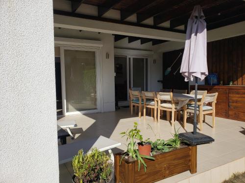 a patio with a table and an umbrella at Casa 9 personas Punta Puyai Papudo in Papudo