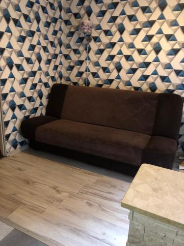 brązowa kanapa w salonie z geometryczną ścianą w obiekcie Noclegi pracownicze centrum w Bytomiu