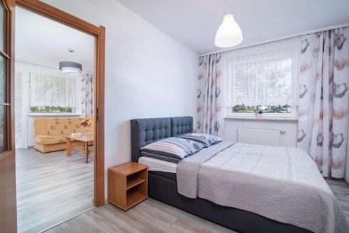 a bedroom with a bed and a chair and a table at Dom Wczasowy Klif & Spa in Władysławowo