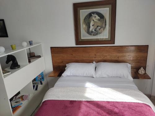 a bed with a wooden headboard in a bedroom at La Bonita in Ezeiza