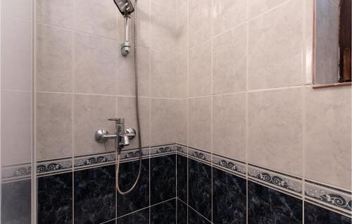 y baño alicatado con ducha y manguera. en Beautiful Apartment In Rtina, Razanac With Kitchen en Miletići