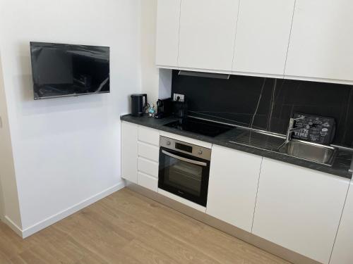 a kitchen with white cabinets and a sink and a microwave at My home in Lecco