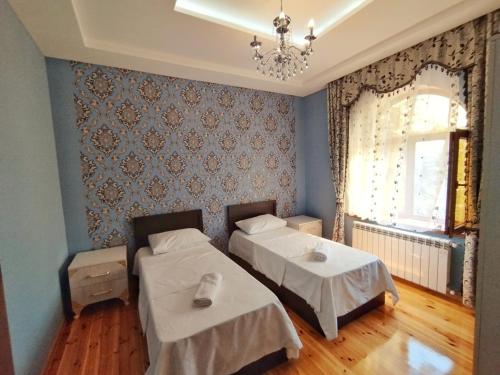 a bedroom with two beds and a chandelier at Dream house in Gabala