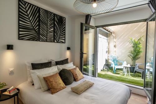 een slaapkamer met een bed en een groot glazen raam bij Appart-hôtel de standing avec jacuzzi privatisable en option in Périgueux
