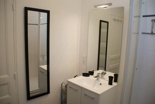 a white bathroom with a sink and a mirror at Le Prieuré: maison de charme proche de Vézelay**** in Asnières-sous-Bois