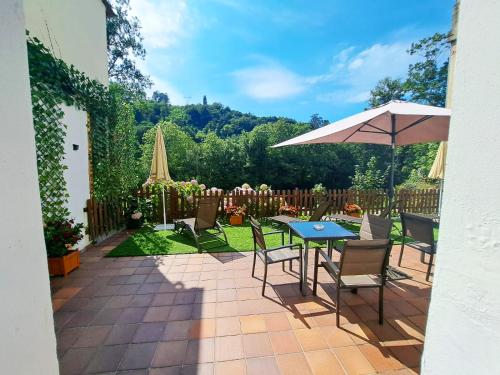 une terrasse avec une table, des chaises et un parasol dans l'établissement Hotel Ciudad Cangas de Onis, à Cangas de Onís