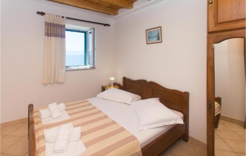 a bedroom with a bed with white pillows and a window at Gorgeous Home In Brist With House Sea View in Brist
