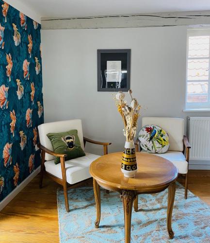 a living room with a table and a couch and a chair at Vintner Suites in Neustadt an der Weinstraße