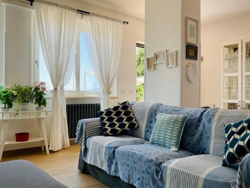 una sala de estar con un sofá azul con almohadas. en Residenza Gli Oleandri, en Formia