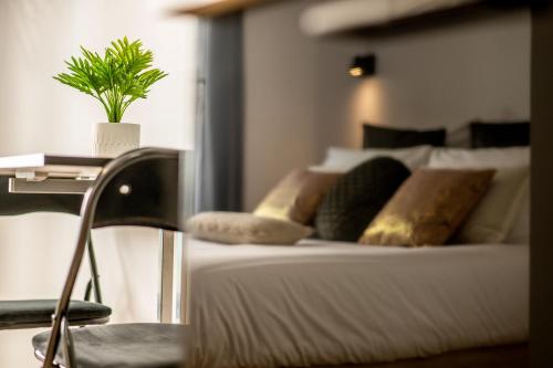 a bedroom with a bed with a potted plant on it at Appart-hôtel de standing avec jacuzzi privatisable en option in Périgueux
