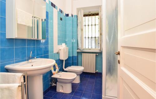 La salle de bains bleue est pourvue de toilettes et d'un lavabo. dans l'établissement Nice Home In Monforte Dalba With Wifi, à Monforte dʼAlba