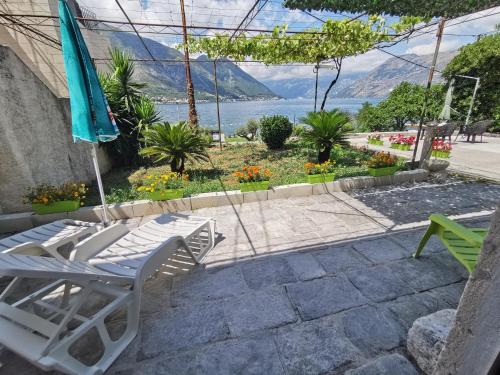 a patio with a table and chairs and an umbrella at Trinity Apartment Seafront in Kotor