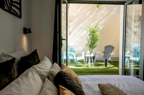 a bedroom with a bed and a patio with chairs at Appart-hôtel de standing avec jacuzzi privatisable en option in Périgueux